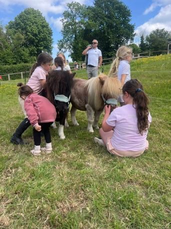 Children interacting with Shetland therapy ponies during an outdoor session in Kent.